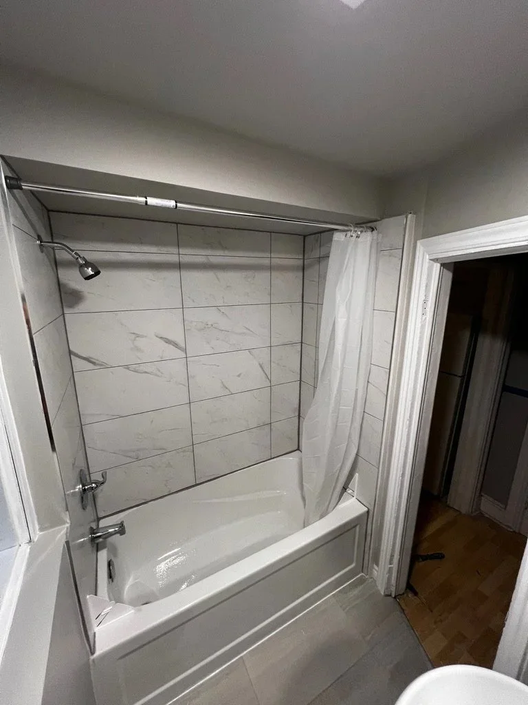 Bathtub and tiled shower surround in Meiju’s compact bathroom refresh.