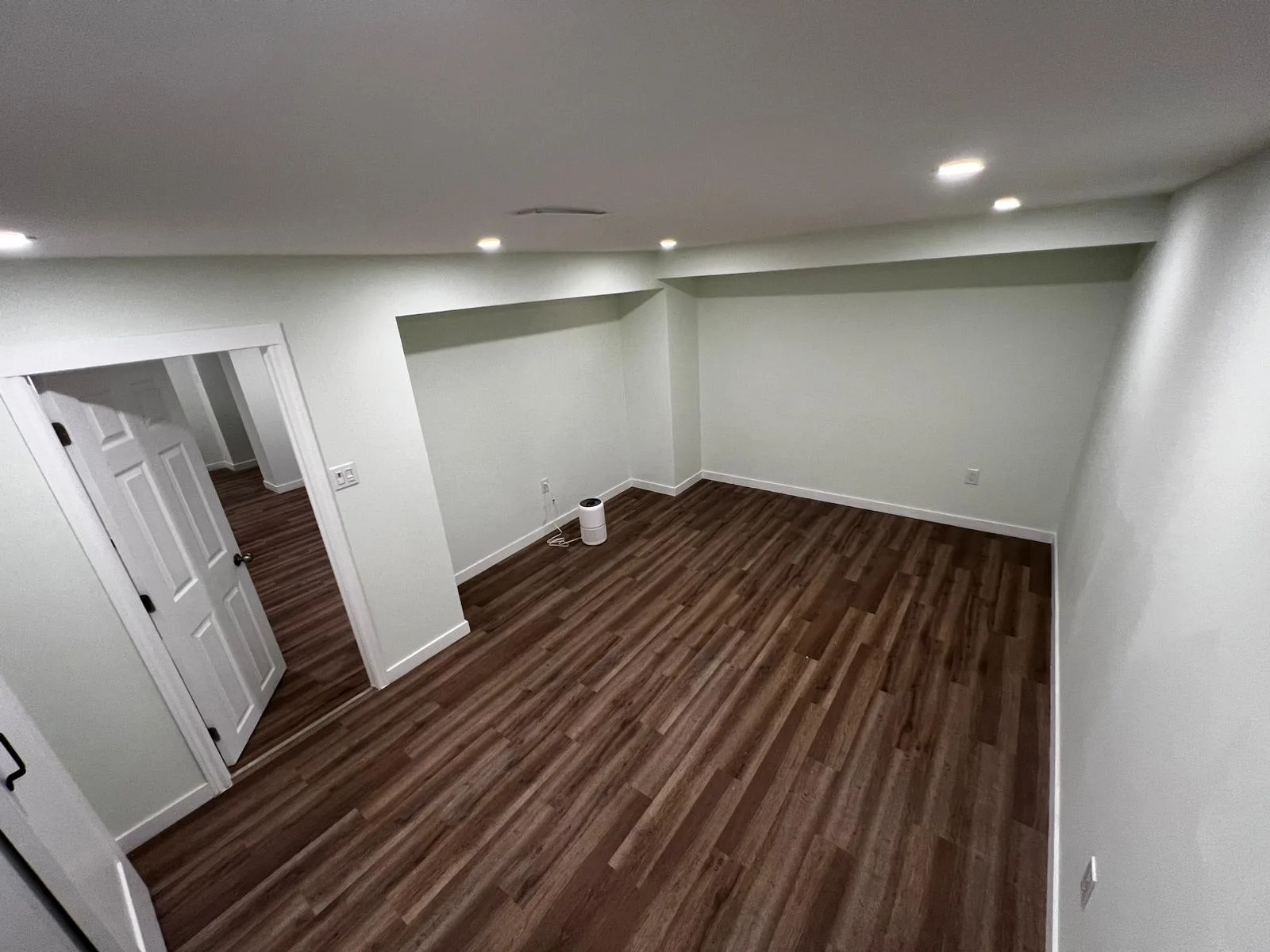 Dark-toned plank flooring continuing through a doorway in a Meiju flooring reference.
